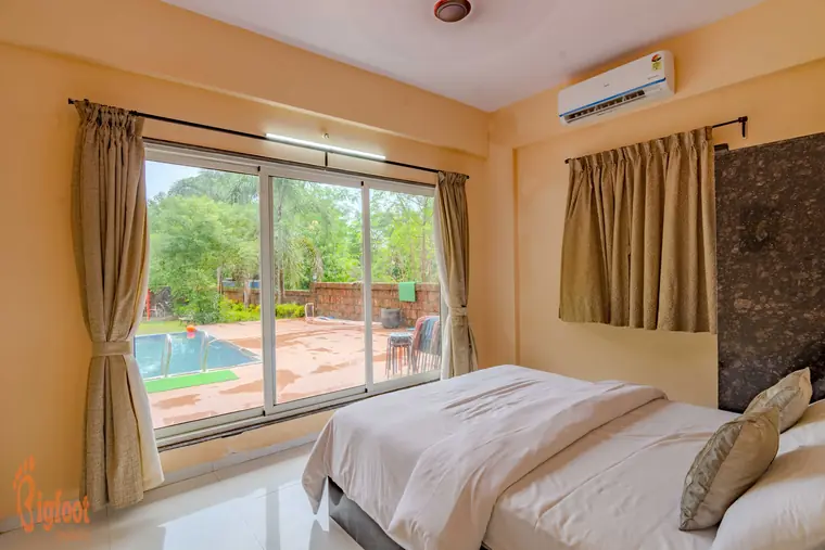 Bedroom at Hideaway Villa with garden views and a wooden wardrobe